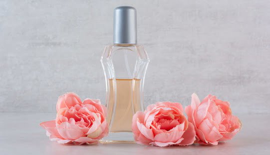 Close up photo of fragrance bottle with flowers. High quality photo